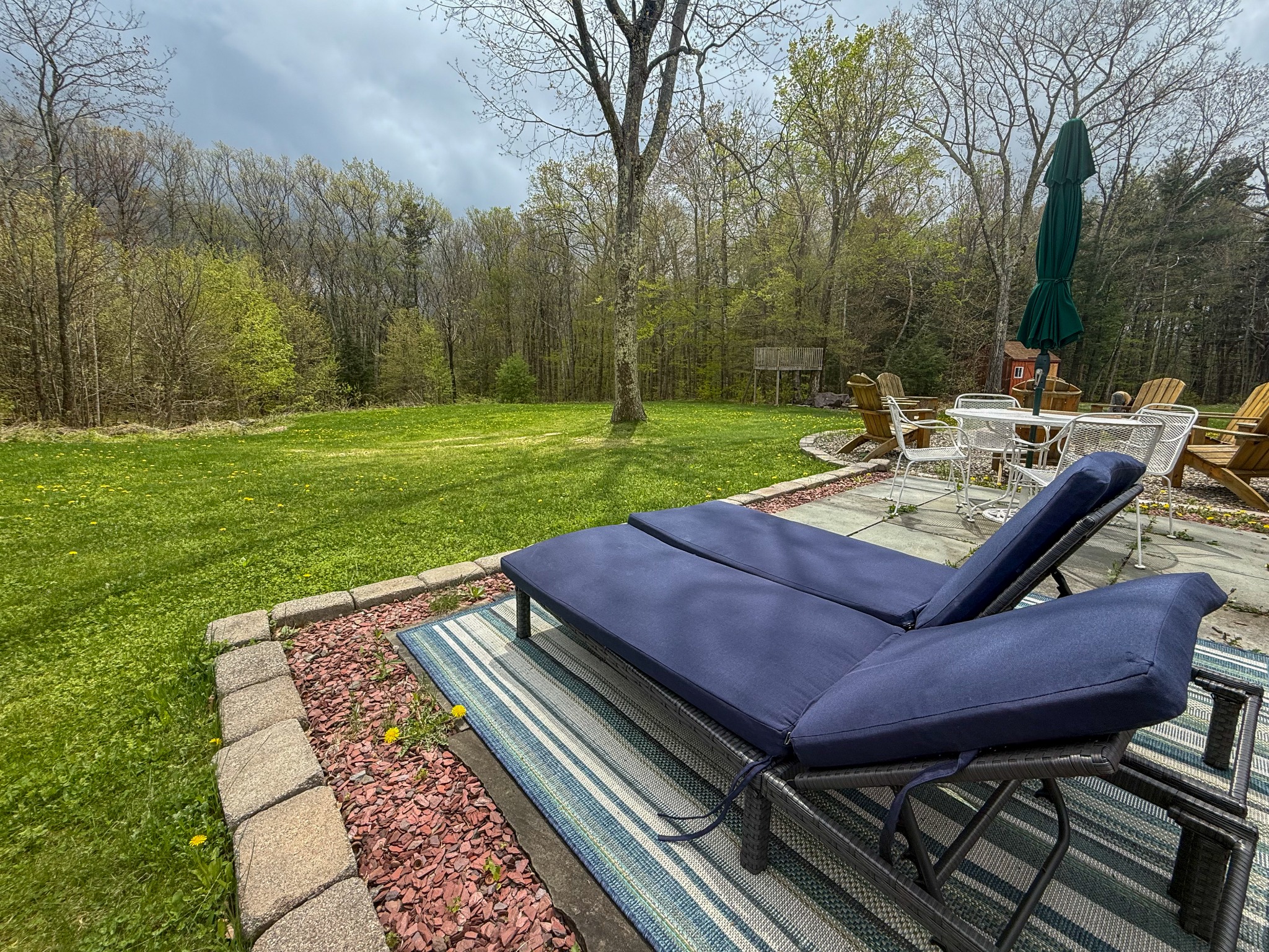 Lounge chairs overlooking the large private lawn and woods