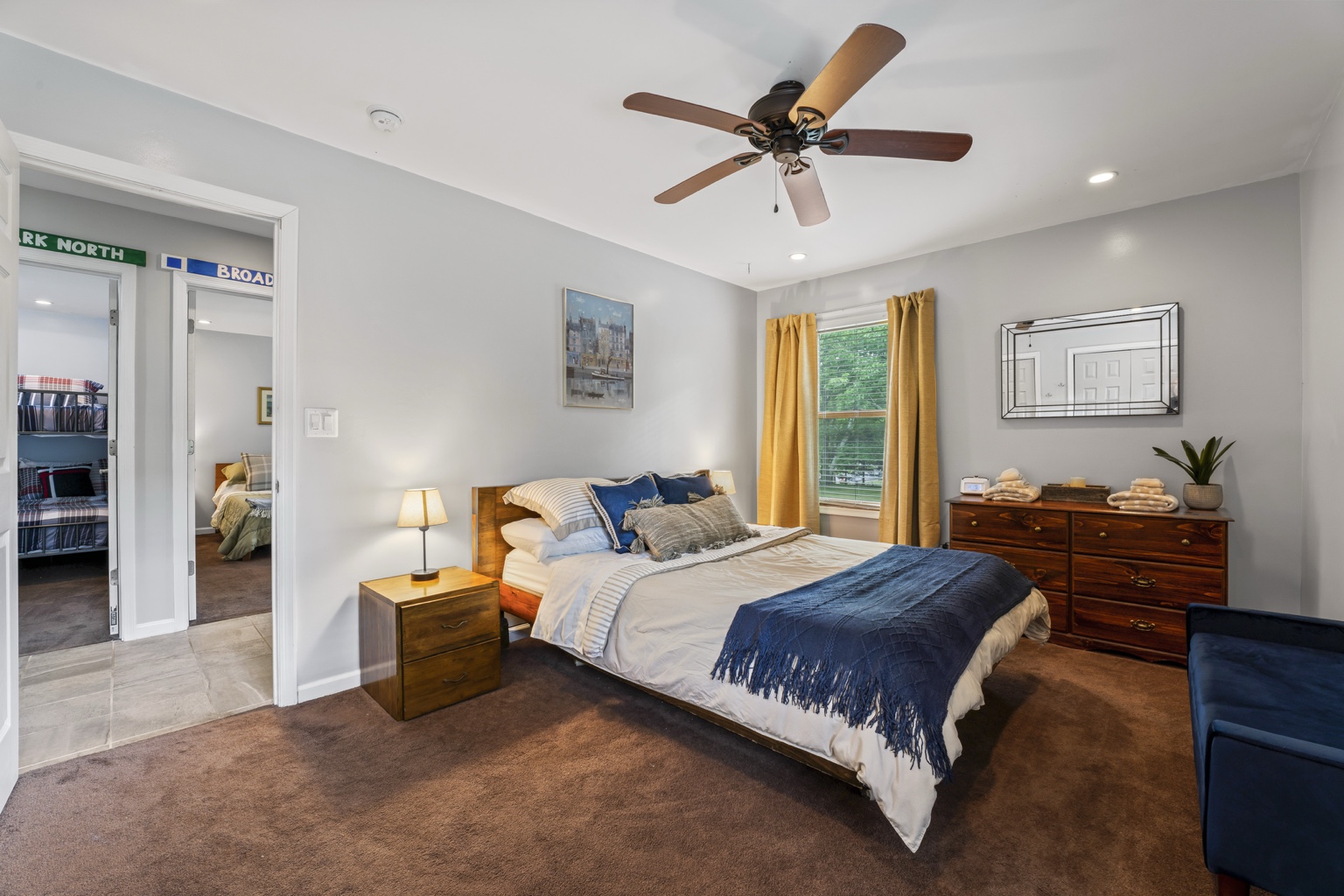 Queen bedroom with blue accents and adjoining hall